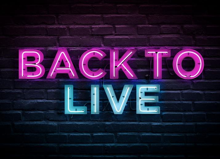 Back To Live - letters lit up against a brick wall