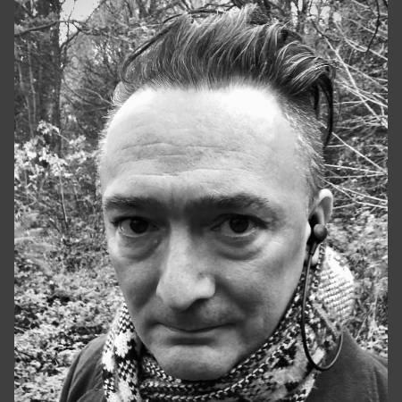 Portrait headshot photograph of Adam P McCready, looking to camera with woods in the background