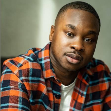 Photograph of David Alade wearing a checked shirt - looking to camera