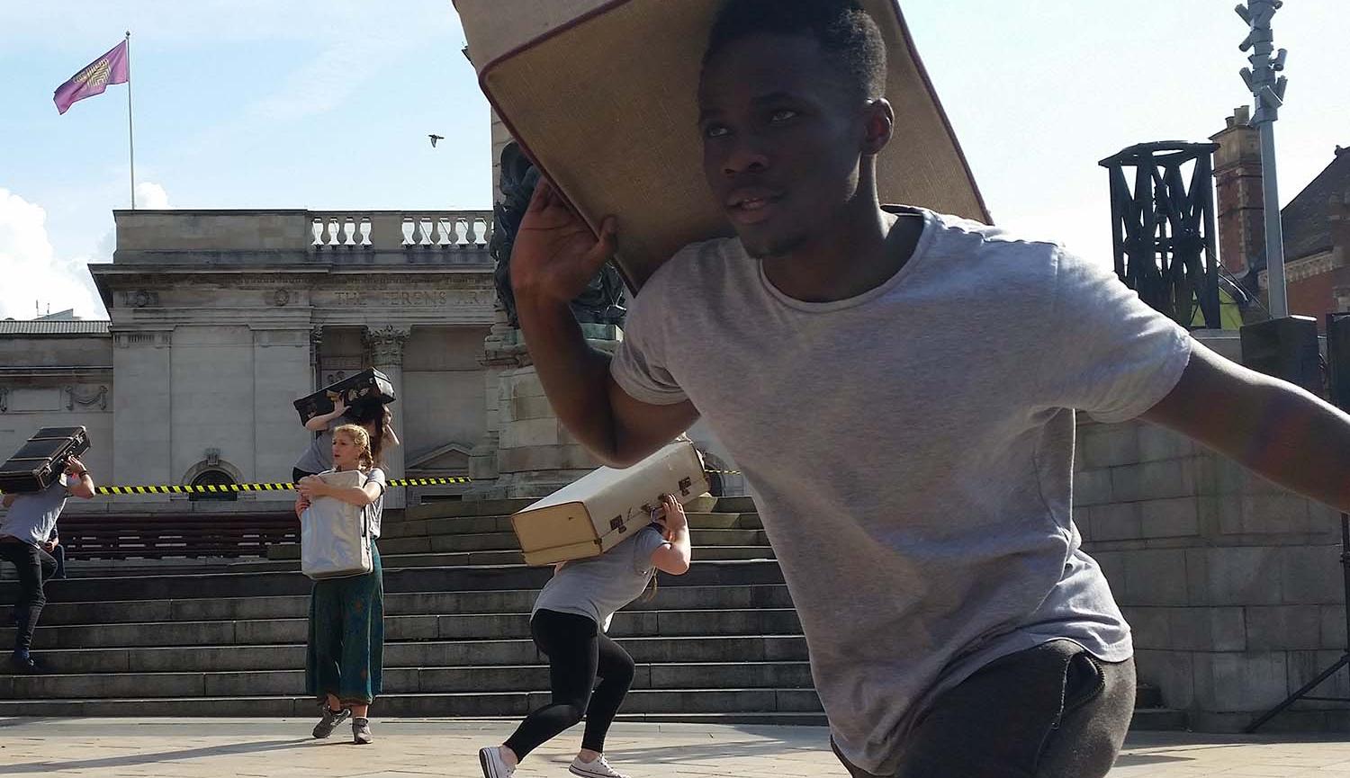 Youth Theatre presentations young man carrying suitcase