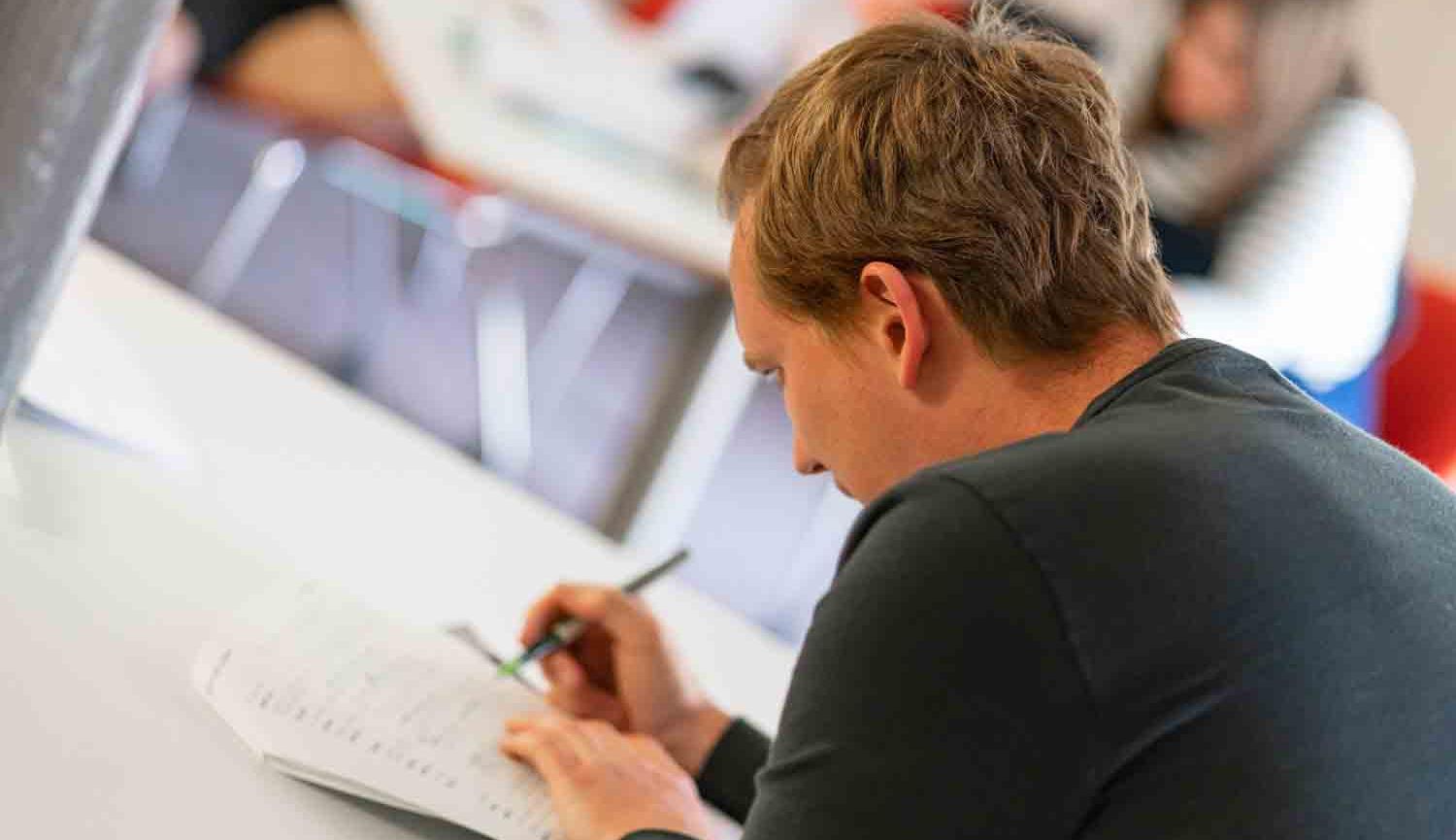 Photo of person writing at table