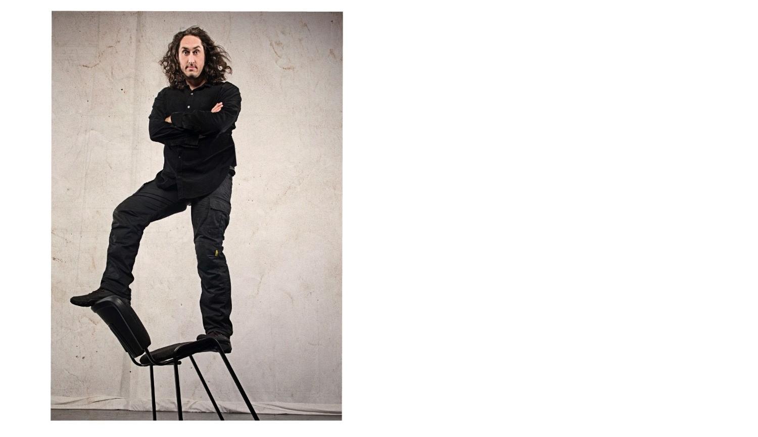 Ross Noble standing on a chair