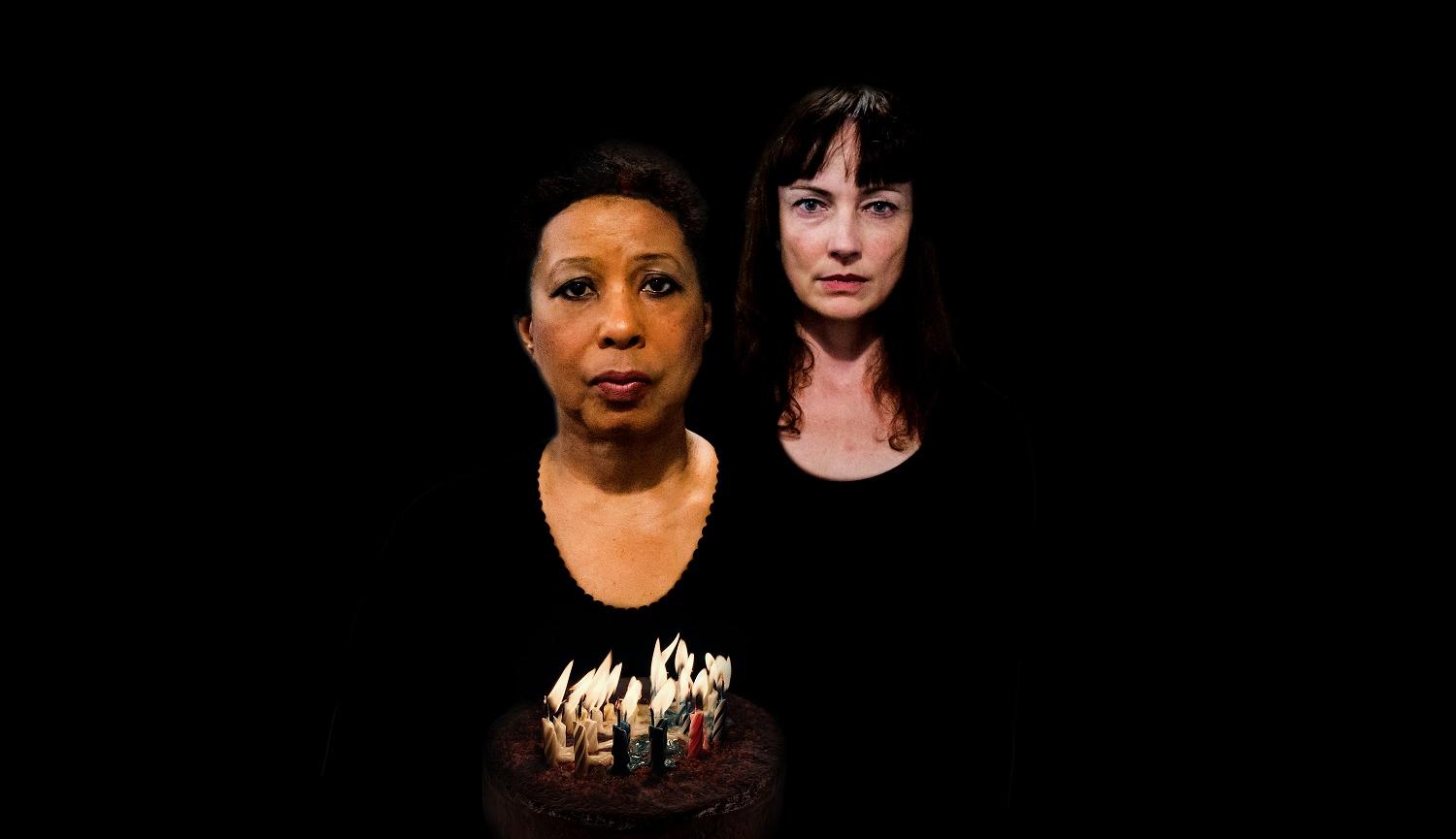 two women standing in the dark/black background