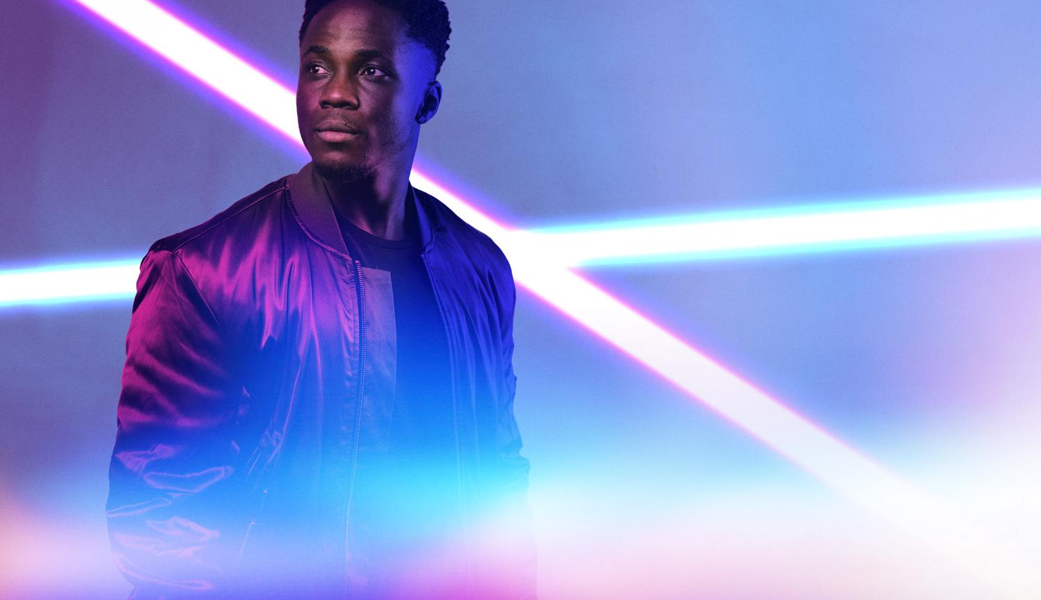 Photo of man with bright lights behind and in front of him