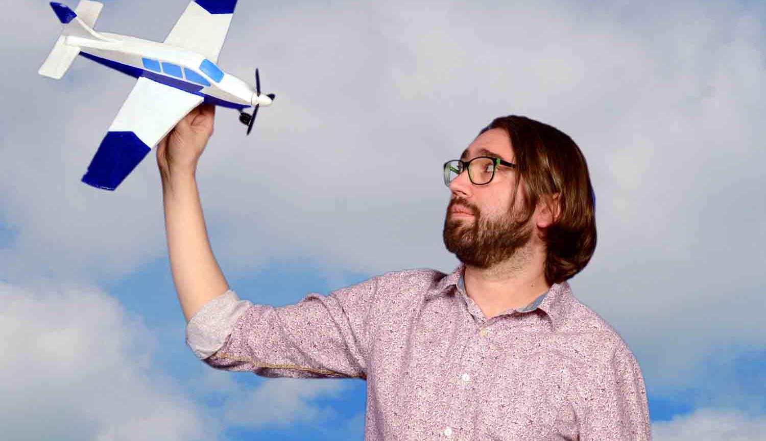 Man holding model airplane in the air