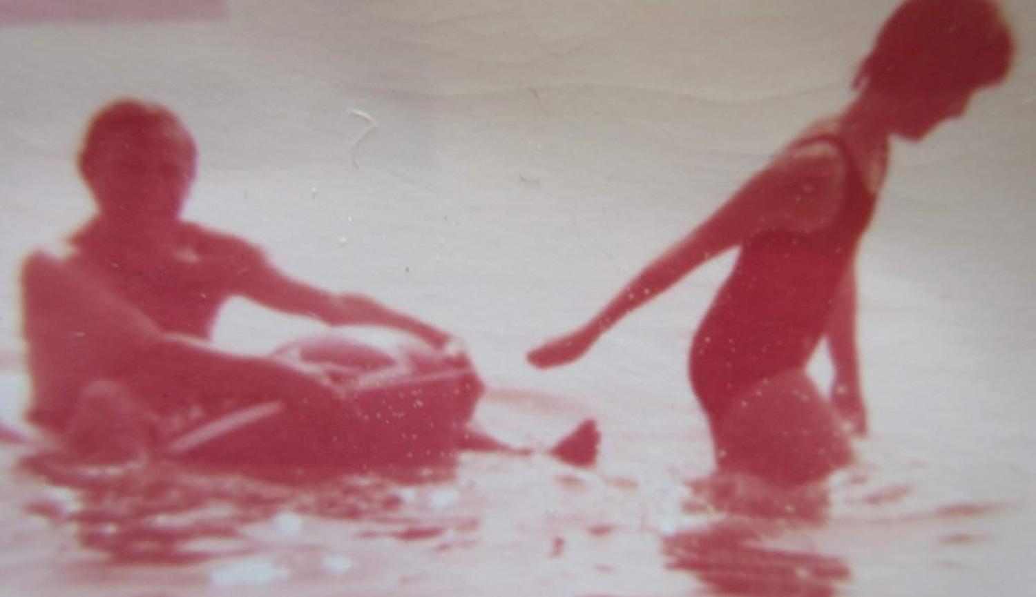 Sepia photograph of two people in the sea