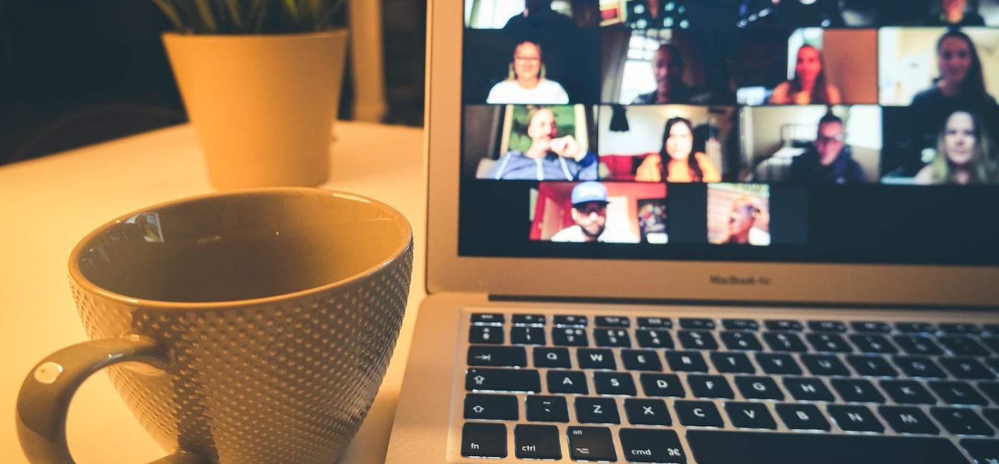 Cup next to laptop screen showing Zoom meeting