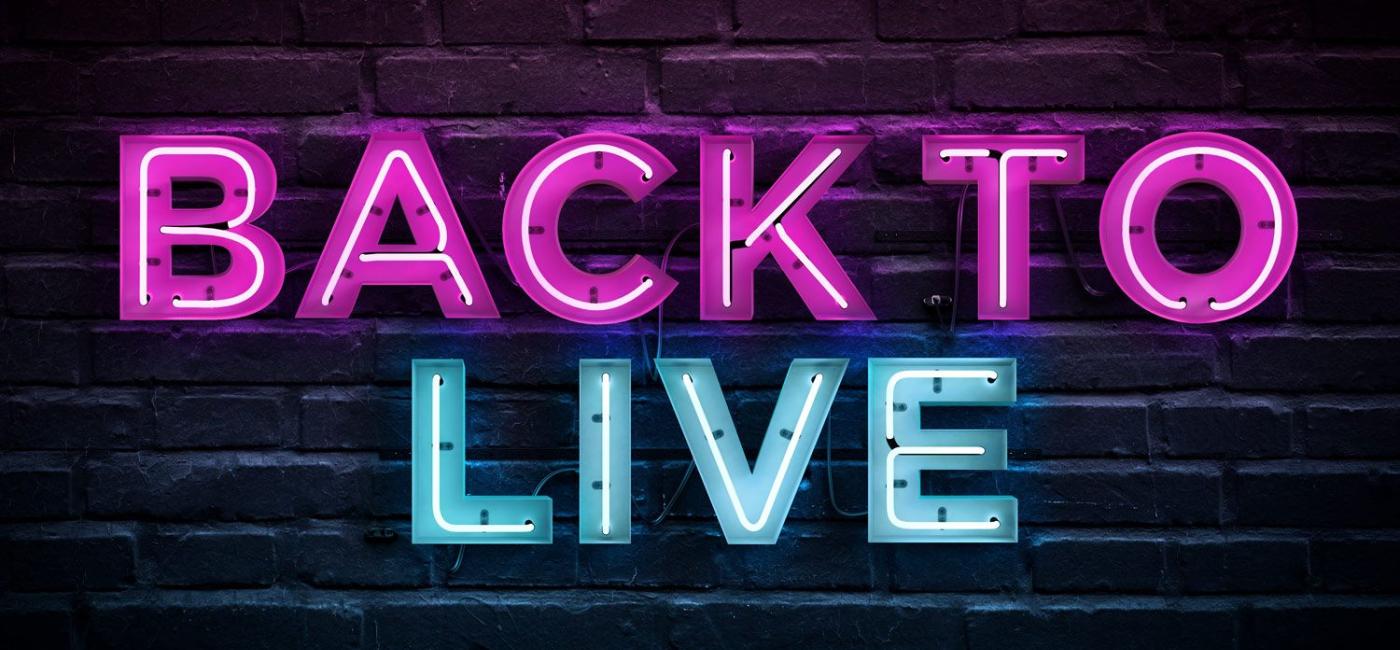 Back To Live - letters lit up against a brick wall
