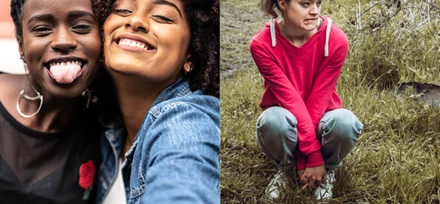 Two girls taking a selfie, one with braids in her hair and another girl in a red jumper sitting on a grassy bank