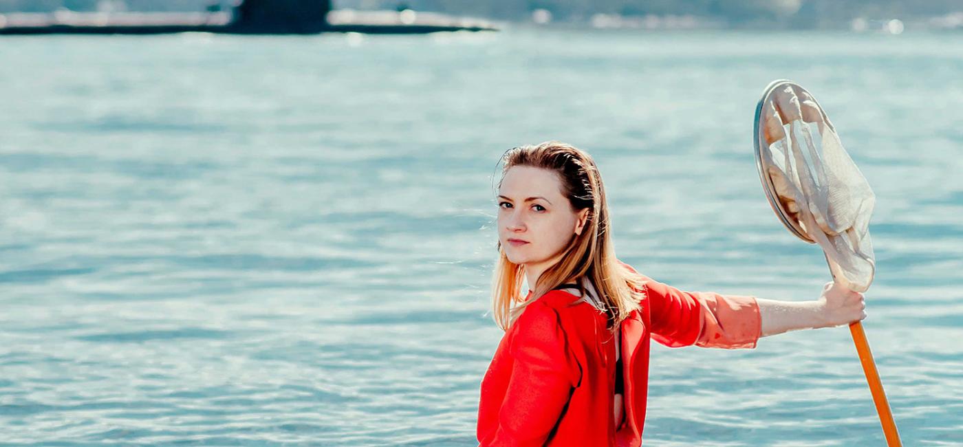 Woman in water in front of submarine 