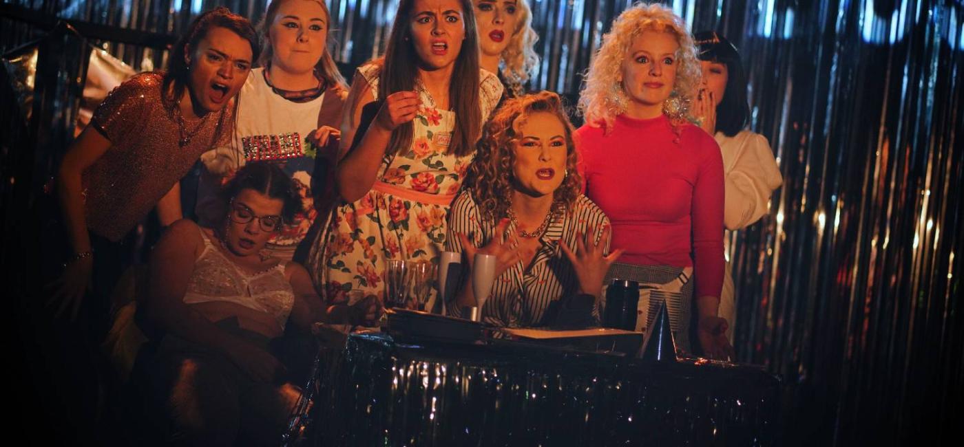 8 cast members of Bonnie & Fanny's Christmas Spectacular standing in front of a glitter curtain