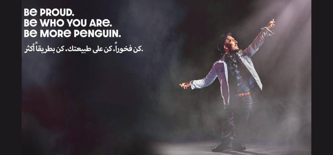 Hamzeh Al Hussien on stage with words Be Proud. Be Who You Are. Be More Penguin.
