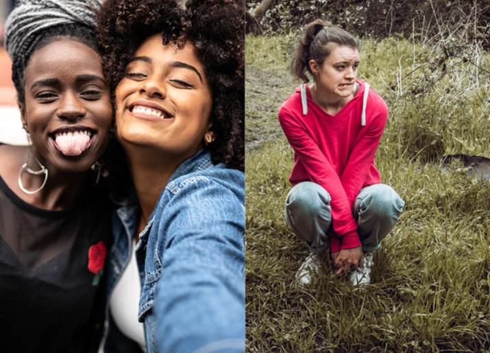 Two girls taking a selfie, one with braids in her hair and another girl in a red jumper sitting on a grassy bank