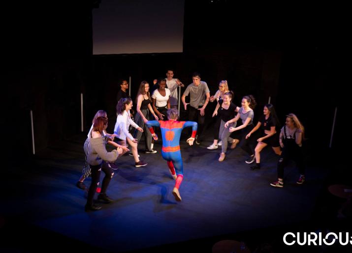 Young People in a circle and young person in spiderman costume