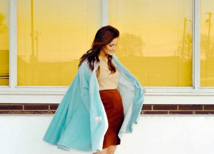 Photo of woman in front of window wearing cape