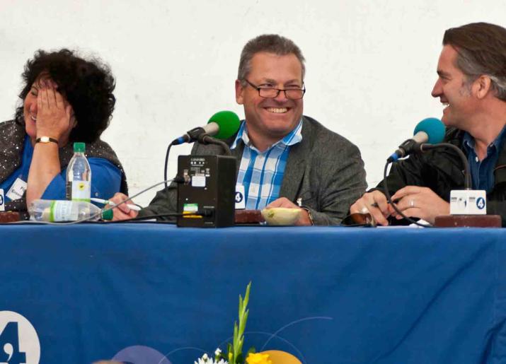 Panel of three people sat behind table covered in blue cloth