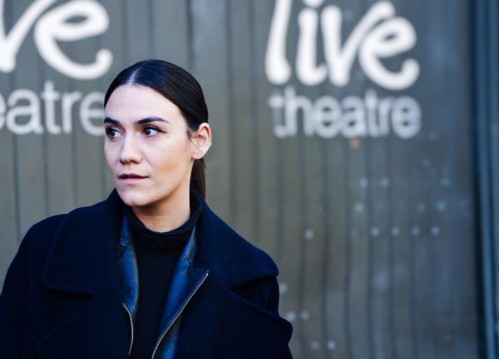 Nadine Shah standing in front of the Live Theatre doors looking off to her right