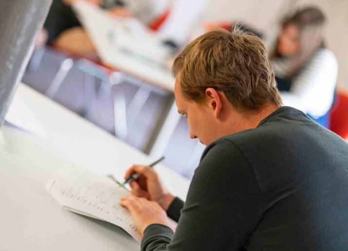 Photo of person writing at table