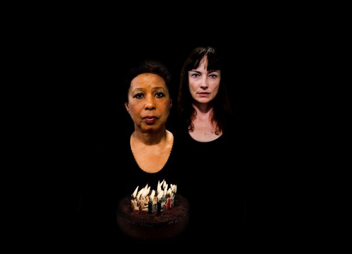 two women standing in the dark/black background