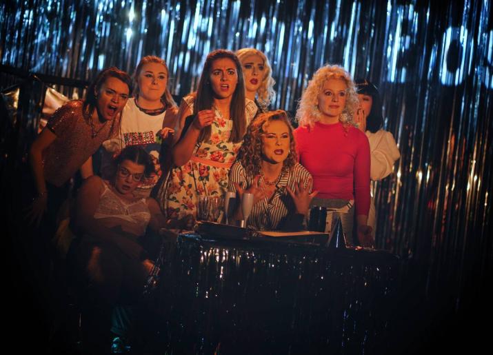 8 cast members of Bonnie & Fanny's Christmas Spectacular standing in front of a glitter curtain