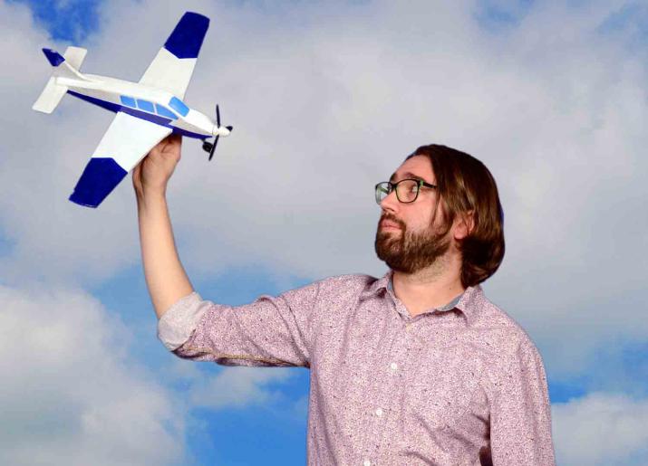 Man holding model airplane in the air