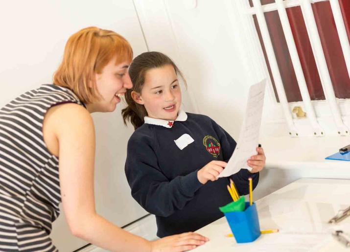 Woman helping child with writing